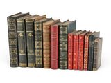 several old books are lined up in a row on a white surface