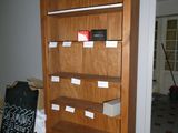 une bibliothèque en bois avec de nombreuses caisses posées par terre