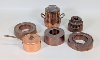 de nombreux types de casseroles et poêles en cuivre sur la table