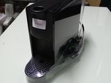 une machine à café posée sur une table blanche