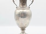 a silver vase that is sitting on a table
