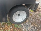 un camion noir avec un pneu crevé, garé sur le bord de la route