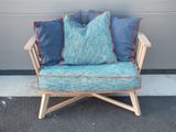 une chaise en bois avec des coussins bleus, posée devant un mur