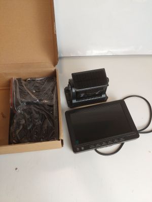 une boîte contenant un appareil photo et une tablette, posée sur une table