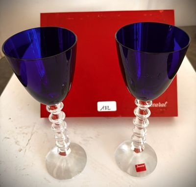 deux verres à vin posés sur une table, à côté d'une boîte rouge
