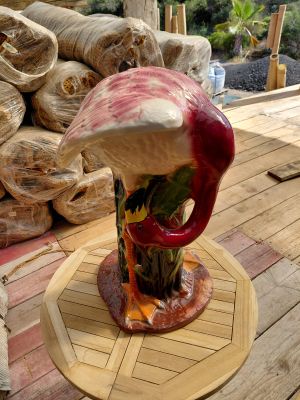 un vase orné d'un oiseau, posé sur une table en bois