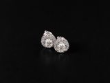 a pair of diamond earrings on a black surface