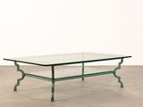 a glass coffee table with metal legs and a glass top