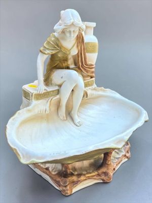 a figurine of a woman sitting on a shell