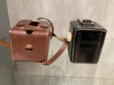 un petit appareil photo fixé à un étui marron