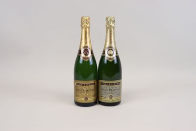 two bottles of champagne sitting next to each other on a white surface
