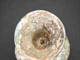a close up of a small vase on a black surface