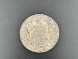 a silver coin on a black surface
