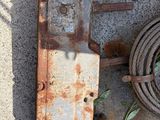 a rusted metal object on the ground next to a rope