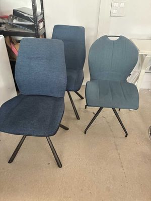trois chaises bleues placées les unes à côté des autres dans une pièce