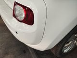 a close up of a white car with a red tail light