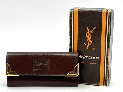 YVES SAINT LAURENT. Porte-clés en cuir marron, gauffré du mo…