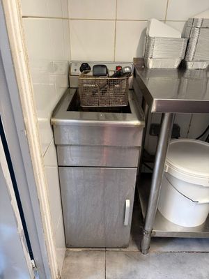 a small kitchen with a sink and a trash can in it