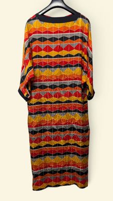 an image of a dress hanging on a hanger on a wall