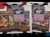 Deux paquets de cartes Pokémon se trouvent dans un emballage sur fond noir.