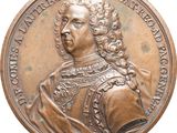 a close up of a bronze medal with a man in a dress