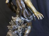 bronze statue of a boy with a dog on a rock