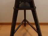 une petite table avec un plateau noir posée sur un piètement en bois