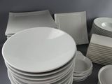 a lot of plates and bowls on the table