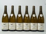 six bouteilles de vin sont alignées sur une table