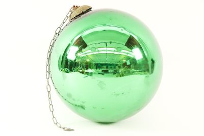 shiny green christmas ball ornament with chain on white background