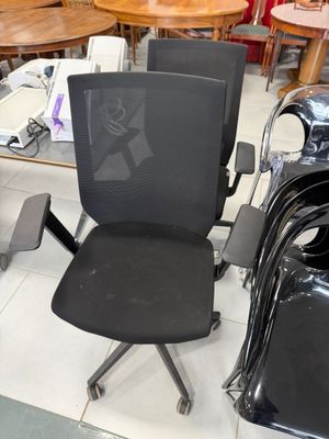 une chaise de bureau noire et une chaise noire posée par terre