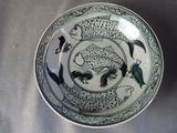 une assiette bleue et blanche ornée d'un motif de poisson