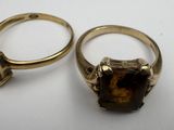 two gold rings with a brown stone and a pink stone