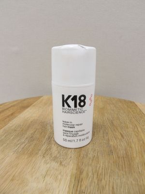 the bottle is sitting on a wooden table next to a white wall