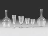 a group of wine glasses and a vase sitting on a table