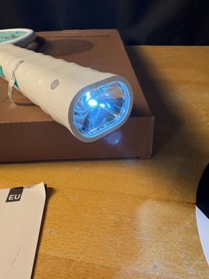 une brosse à dents électrique blanche posée sur une boîte