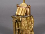 statue of a woman sitting at a desk with a cross on top of it