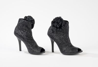 deux paires de chaussures noires à talons hauts ornées d'une fleur sur le talon
