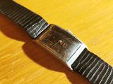 a close up of a wrist watch on a wooden table