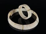 a pair of pearl bracelets on a black surface
