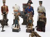 seven figurines of soldiers and a dog on a table