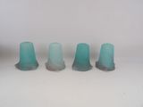 trois vases en verre bleu posés sur une table blanche
