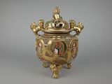 a gold and blue vase with a lion on top of it