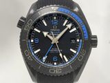 La montre noire et bleue est exposée sur une surface blanche.