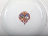 a white plate with a picture of a coat of arms on it