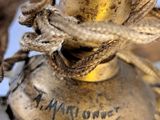 a close up picture of a brass lamp with a rope around it