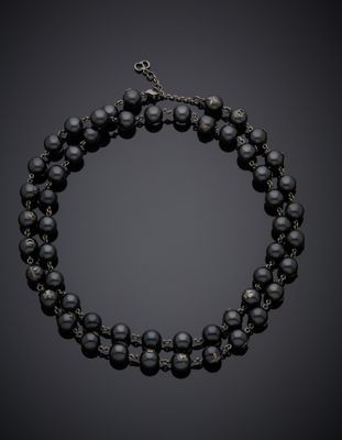 un collier de perles noires et de diamants muni d'un fermoir en argent