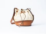 un sac seau blanc avec une anse marron sur fond blanc
