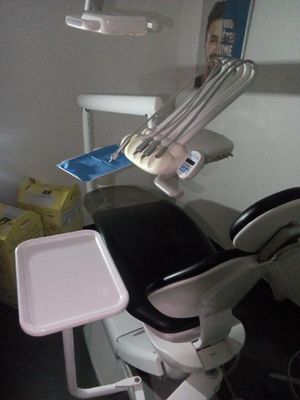 un fauteuil de dentiste muni d'un plateau, dans une salle