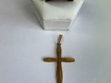 une croix et une bague en or posées sur une table blanche
